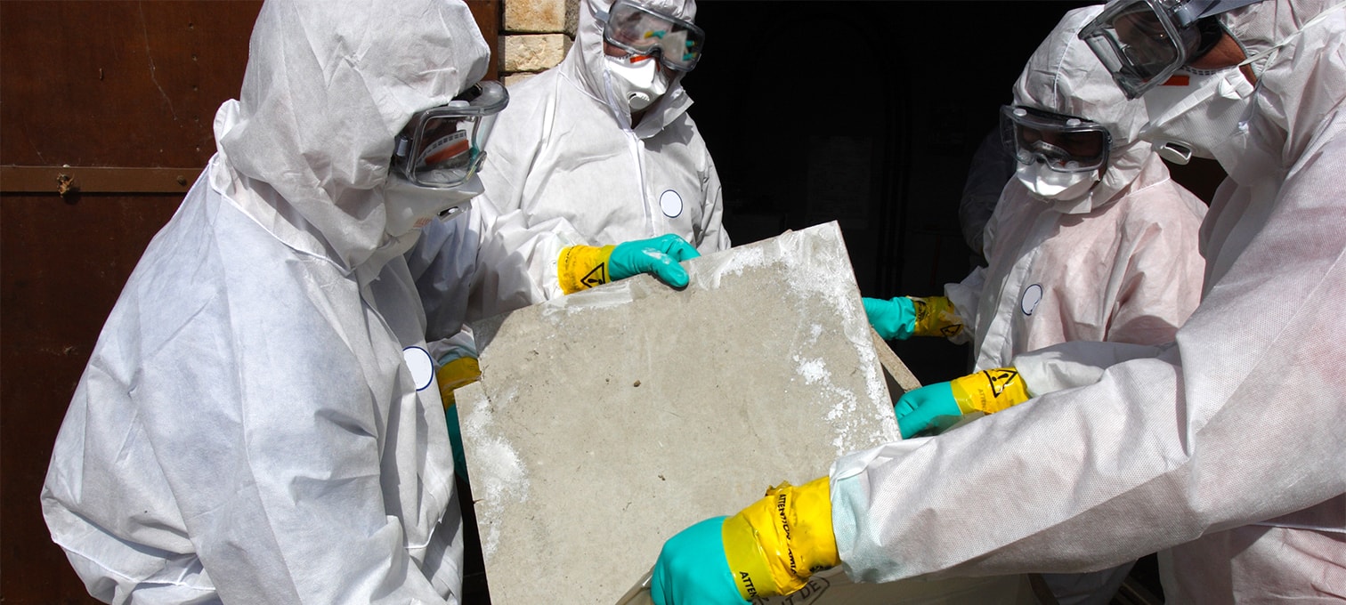 People in hazmat suits, removing asbestos from a building.